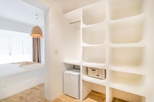 a white bedroom with a bed and white shelves at Giritimu B'yaz in Selimiye