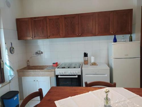 a kitchen with a stove and a white refrigerator at Casa Paola in Cetona
