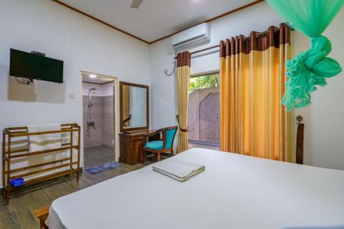 a bedroom with a bed and a desk and a window at Ocean Gate Negombo in Negombo