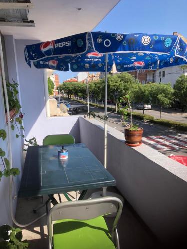 a table and chairs on a balcony with an umbrella at Апартамент Иванови in Pomorie