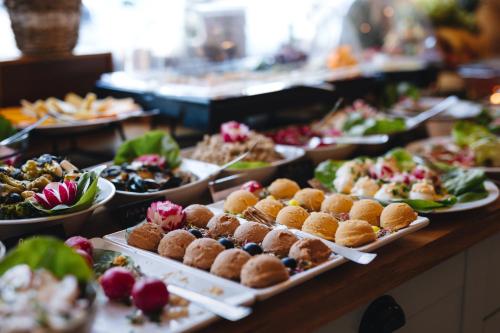 a buffet with many plates of food on a table at So Stay Hotel in Gdańsk