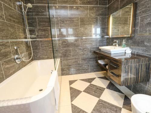 a bathroom with a tub and a sink at Bronte View Hideaway in Keighley