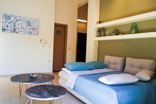 Un dormitorio con una cama azul con almohadas y una mesa en Aggeliki's guest house, en Nauplia