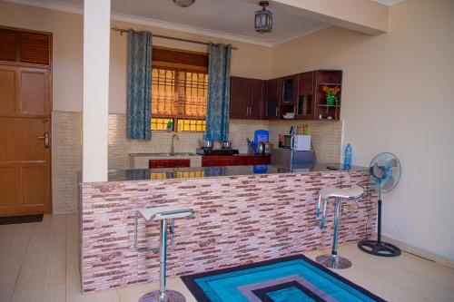 a kitchen with a bar with two bar stools at J & A VILLAS in Mbale