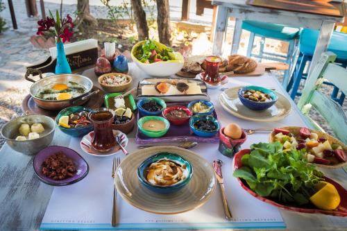 einen Tisch mit Teller mit Lebensmitteln und Schüsseln mit Lebensmitteln in der Unterkunft byaz selimiye in Selimiye