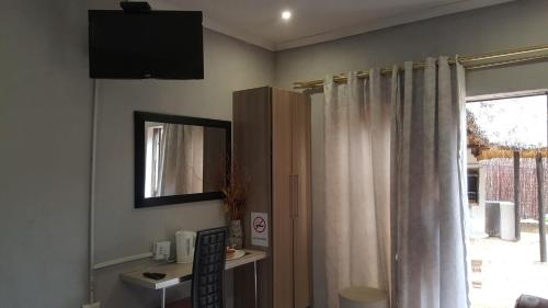 uma sala de estar com um espelho e uma janela em Kadichueni Guest House em Zeerust