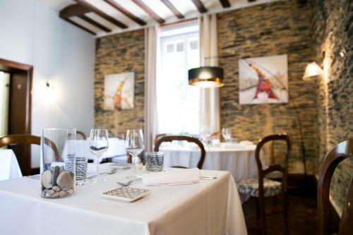 een tafel in een restaurant met een witte tafelkleed bij Logis Auberge De L'ombrée in Combrée