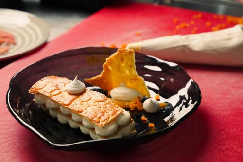 a black plate with food on a red table at Rákóczi Hotel, Tábor és Rendezvényközpont in Sátoraljaújhely