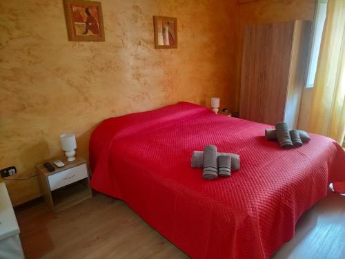 a bedroom with a red bed with two gray pillows on it at B&B Arena Family in Fagnano Castello