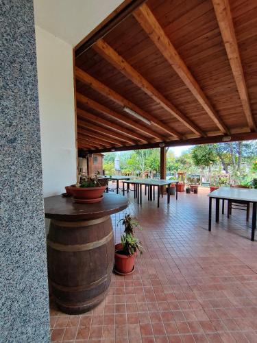 a large patio with tables and a wooden ceiling at B&B da Donatella in Santa Maria Coghinas