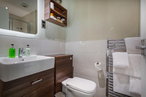 a white bathroom with a sink and a toilet at The Feathers Hotel, Helmsley, North Yorkshire - The Coaching Inn Group in Helmsley