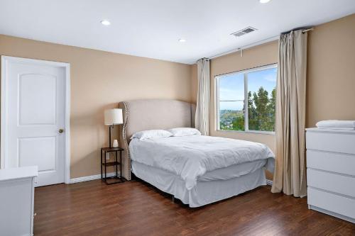 een slaapkamer met een bed en een raam bij City Terrace House only minutes From Down Town LA in Los Angeles