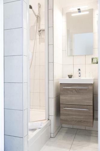 une salle de bain avec une douche, un lavabo et un miroir dans l'établissement Logis Auberge De L'ombrée, à Combrée