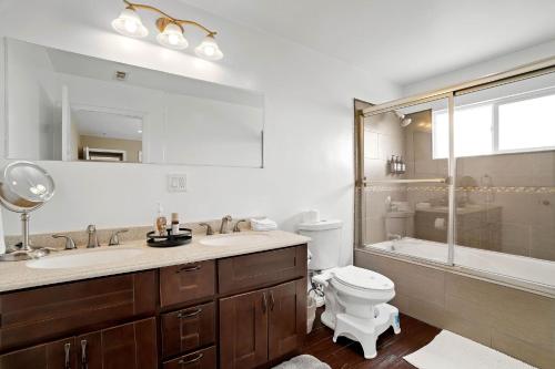 a bathroom with a sink and a toilet and a shower at City Terrace House only minutes From Down Town LA in Los Angeles