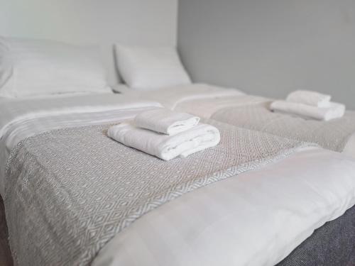 a row of white beds with folded towels on them at Residential Homes Franzén in Helsinki