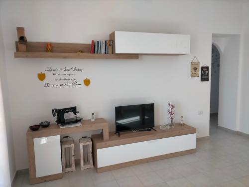ein Wohnzimmer mit einem TV auf der Theke in der Unterkunft Holiday House Chiara in SantʼAntìoco