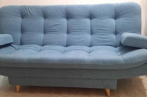 un sofá azul sentado en una sala de estar en Apartamento Cómodo en Medellín, en Bello