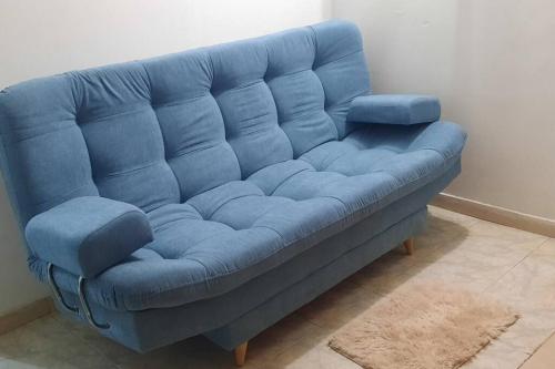 um sofá azul sentado numa sala de estar em Apartamento Cómodo en Medellín em Bello