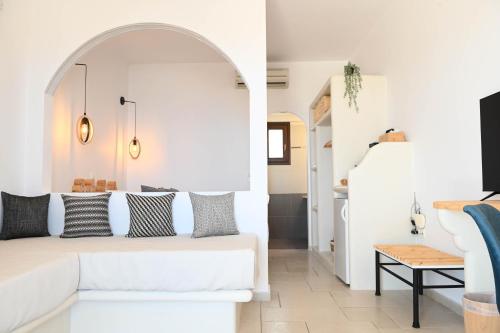 a white living room with a white couch and a stairway at Amerisa Suites & Villa in Fira