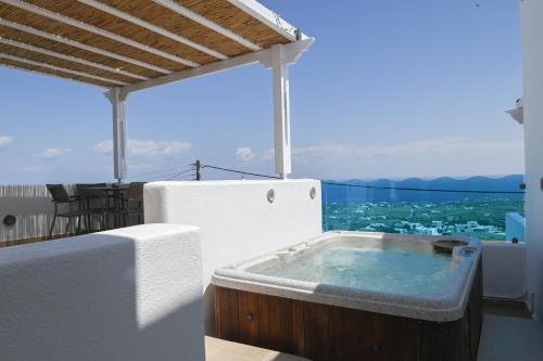 a hot tub on the balcony of a house at Amerisa Suites & Villa in Fira