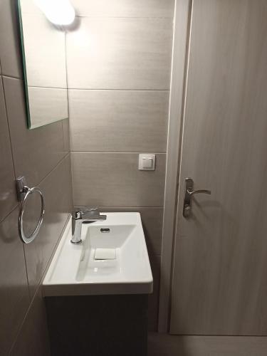uma casa de banho com um lavatório branco e um espelho. em Vita vi em Afión