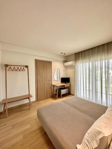 a bedroom with a large bed and a desk at Aerin Residence in Limenaria