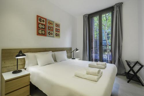バルセロナにあるザ ホワイト フラッツ サン アントニのベッドルーム(大きな白いベッド1台、窓付)