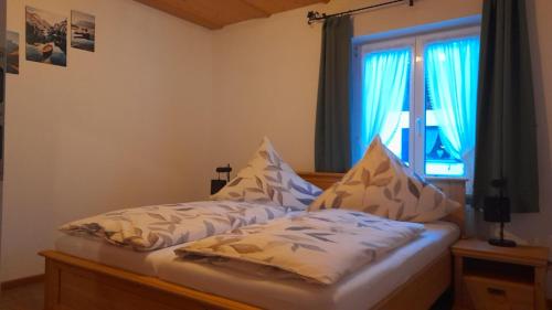 Bett in einem Zimmer mit Fenster in der Unterkunft Ferienhaus Adelia in Mittenwald