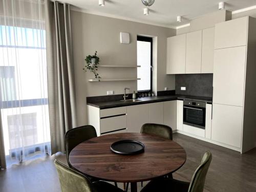 a kitchen with a wooden table and chairs in a kitchen at Bierinu apartamenti in Riga