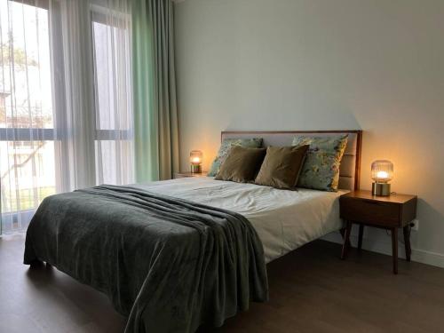 sypialnia z dużym łóżkiem z dwoma lampami na stole w obiekcie Bierinu apartamenti w Rydze