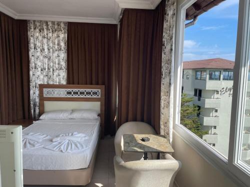 a bedroom with a bed and a large window at Rosella Hotel in Alanya