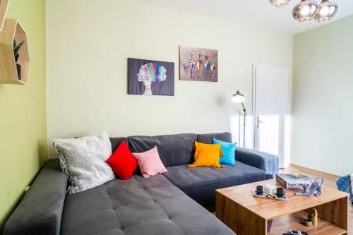 uma sala de estar com um sofá azul com almofadas coloridas em Madrid 2BDR near Metro, Serdika Mall - ACs - Cot em Sófia