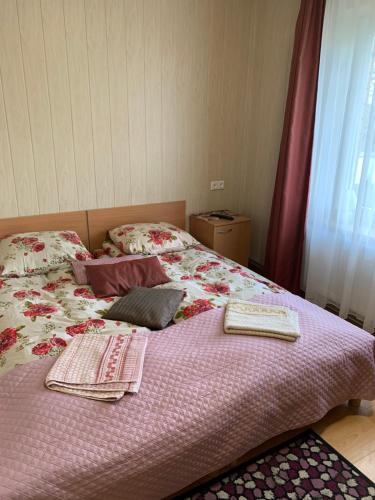 a bed with two blankets and pillows on it at Rotušė in Trakai