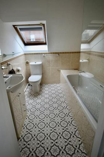 a bathroom with a toilet and a tub and a sink at Vernon Place town centre, Vernon Cottage 3-bed with parking, 1A Vernon Court 2-bed with parking, 1B studio no parking, off the High Street next to Sandford Park in Cheltenham