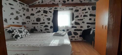een slaapkamer met een muur met zwarte en witte koeienprint bij AL - Adega do Terra in Madalena