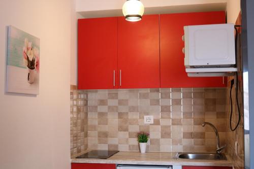 a kitchen with red cabinets and a sink at Apartamentos La Carmen in Arrecife