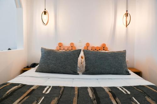 a bedroom with a bed with two pillows at Amerisa Suites & Villa in Fira
