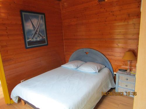a bedroom with a bed in a wooden wall at Locatlantique in Aytré