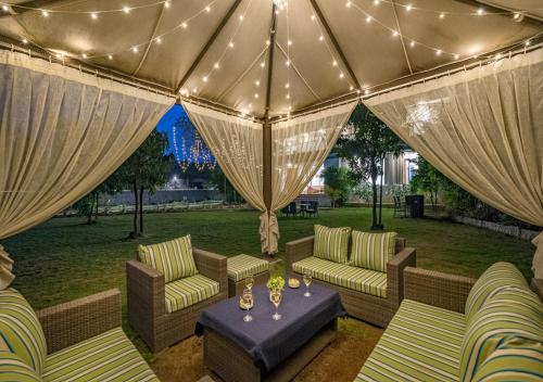 a patio with couches and a table and lights at SaffronStays 7 Seas, Alibaug in Alibaug