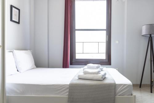 una camera da letto con un letto con lenzuola e asciugamani bianchi di SKG Premium Studios Kastra a Salonicco