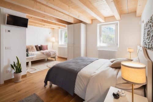 a bedroom with a large bed and a living room at Agriturismo Podere del Bosc in Valmareno