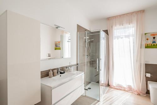 een witte badkamer met een wastafel en een douche bij Padova Albignasego Apartment con terrazzo x7! in Albignasego