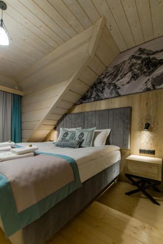 a bedroom with a large bed with an attic at Skansen Holiday in Cholerzyn