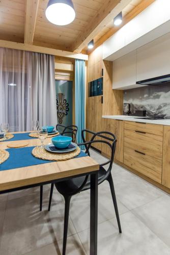 a dining room with a table and chairs and a kitchen at Skansen Holiday in Cholerzyn