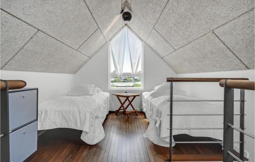 - une chambre mansardée avec 2 lits et une fenêtre dans l'établissement Beautiful Home In Glesborg With House Sea View, à Bønnerup Strand