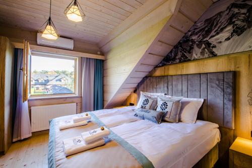 1 dormitorio con 1 cama grande en una habitación en Skansen Holiday en Cholerzyn