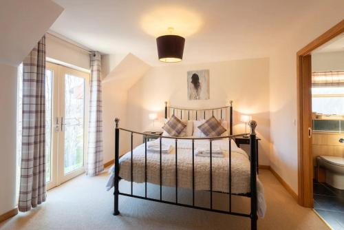 a bedroom with a bed and a toilet and a window at Carn Mhor Lodge in Aviemore