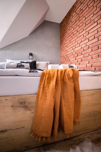 a bedroom with a bed and a brick wall at Wolfpack Guest House in Białka Tatrzańska