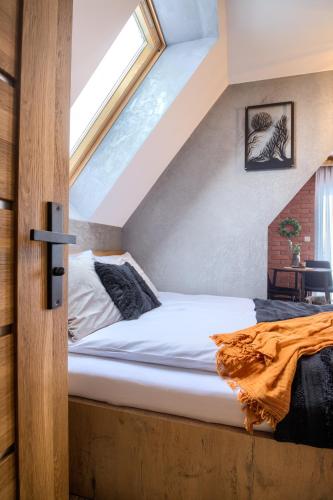 a bed in a room with a window at Wolfpack Guest House in Białka Tatrzańska