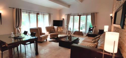 ein Wohnzimmer mit einem Sofa und einem Tisch in der Unterkunft Maison Prestige Saint Tropez by Roberto Geissini in Grimaud